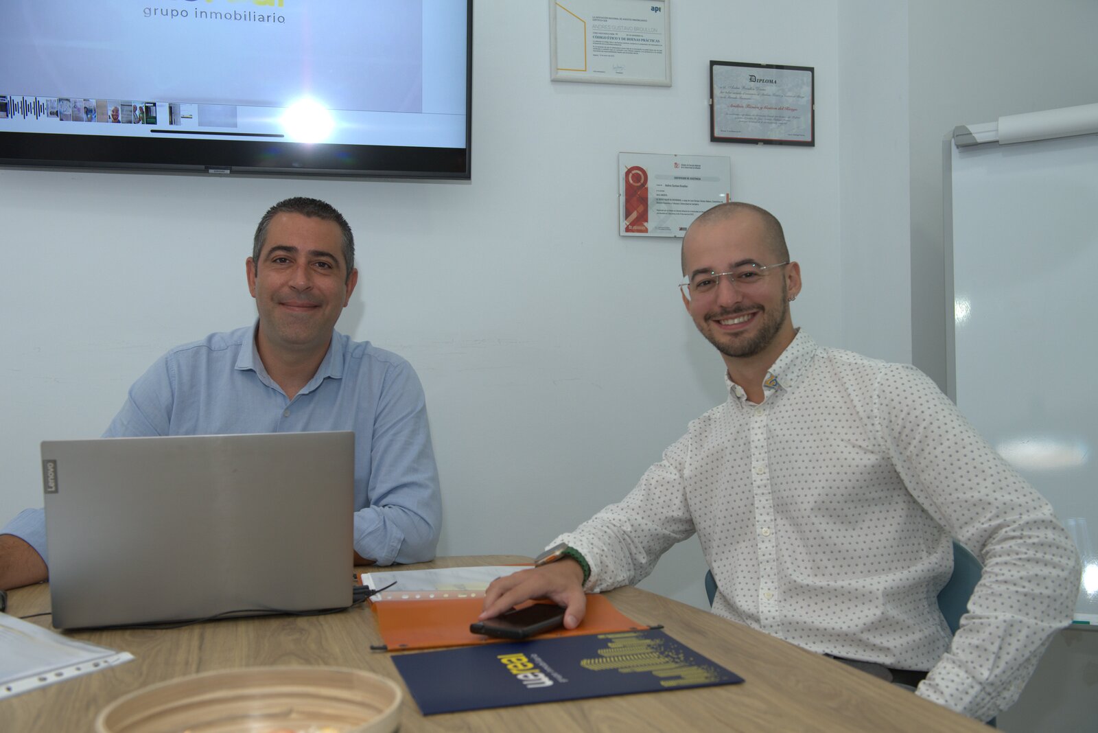 Asesores de WeSeguros revisando una póliza con un cliente en la oficina de Wereal