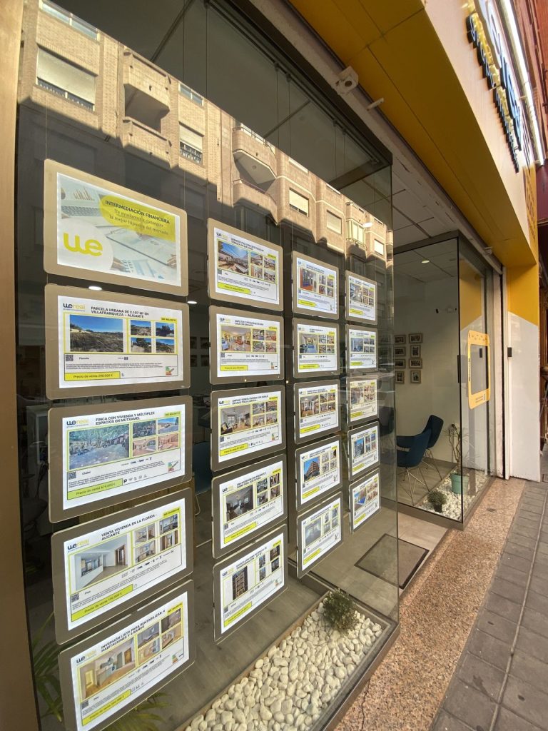 Wereal shop window with homes for sale on calle Arquitecto Morell in Alicante