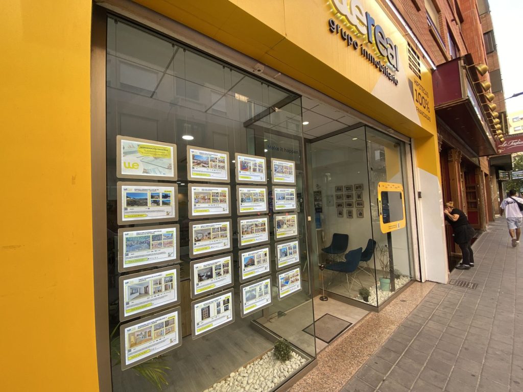 Escaparate de la agencia Wereal con fichas de viviendas en venta en Alicante