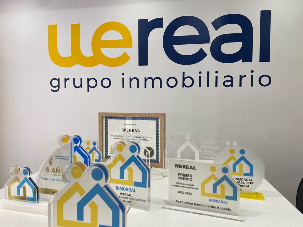 Premios y trofeos de INMOADAL bajo el logo de Wereal Grupo Inmobiliario en nuestra oficina de Alicante